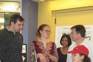 MIT student Julia Kiberd '08 pedals the specially adapted exercise bike, generating power for the laptop she's using to check her e-mail. Helping to host the Student Center display of the bike are (from left) technical instructor Stephen Rudolph, Kendra Johnson '09, IT energy coordinator Laxmi Rao and civil and environmental engineering senior research associate John Germaine.