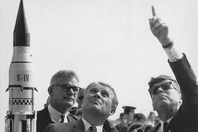 Then-NASA Deputy Administrator Robert Seamans, a former dean of the School of Engineering at MIT, stands behind Dr. Wernher von Braun as he explains the Saturn Launch System to President John F. Kennedy.