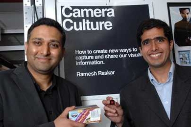 Ramesh Raskar, left, holds box with conventional barcode,
while Ankit Mohan holds a prototype of new Bokode.