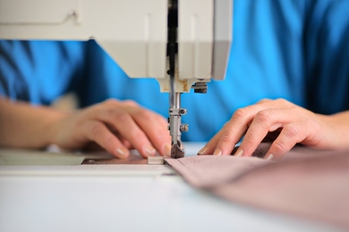 A person's hands using a sewing machine