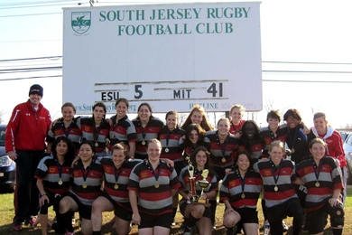 The MIT women's rugby club team poses with its hardware after winning the National Championship.
