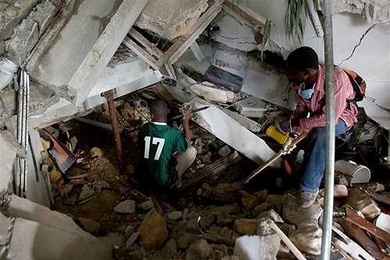 Two Haitians use crowbars, shovels and their hands to clear rubble in an attempt to reach survivors at the Montana hotel that collapsed after an earthquake.