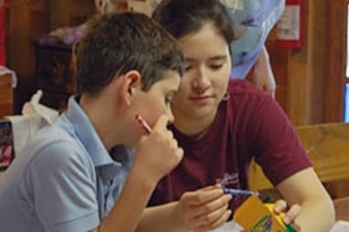 Camp Kesem camper Ryan Johnson and Caroline Huang ‘10 choose crayons for Ryan’s International Day flag. 

