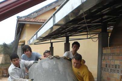 In addition to designing alternatives for a new low-energy school campus for 800 students, the MIT students conducted a service project by building a kitchen for a small local school. Here, MIT graduate students in architecture (left to right) Joseph Nunez, Adam Galletly, Zachary Lamb, Yan-Ping Wang, and Lee Dykxhoorn move a concrete cistern into place.