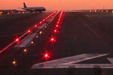 Takeoff Hold Lights are shown implemented at the Los Angeles International Airport. These components of the Runway Status Lights system are placed at departure positions and indicate to pilots that it is unsafe to take off because a runway ahead is occupied by another aircraft.