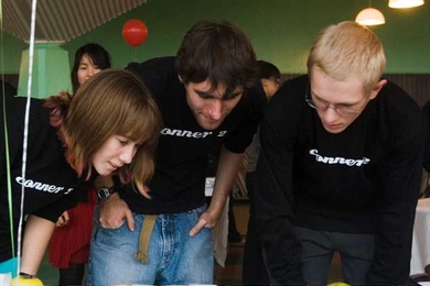 Freshman Caitlin Sample, left, sophomore Andras Kiss and freshman Brandon Lowe check out the entries in the category “Apple Art.” 
