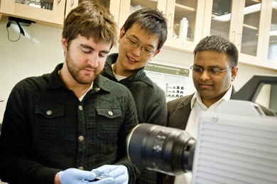 Kripa Varanasi, right, a professor of mechanical engineering, and graduate students Hyuk-Min Kwon, center, and Adam Paxson stand in front of the high-speed camera used to capture images of water droplets on a surface.