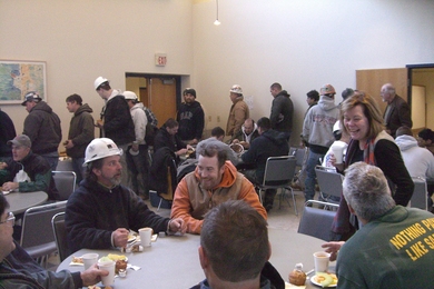 Maseeh Hall Headmaster Suzanne Flynn, right, chats with construction workers at the coffee hour.
