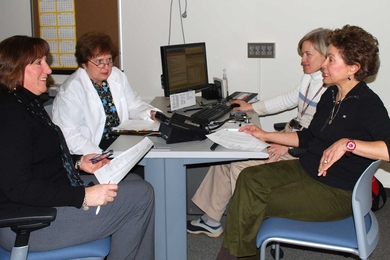 Staff in MIT Medical's Community Care Center discuss patient care. Left to right: nurse care managers Kim Carroll, Cathy Dwyer, Eleanor Woodard and Marie Avelino.