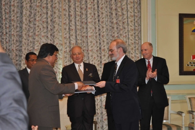 The signing ceremony creating the Malaysia Institute for Supply Chain Innovation (MISI), a joint initiative between the government of Malaysia and MIT. Malaysia Prime Minister Najib Tun Razak (center) looks on while MIT Chancellor Eric Grimson (right) exchanges documents; at far right is Yossi Sheffi, Director of MIT's Center for Transportation and Logistics