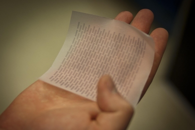 Barr holds a sheet of paper that has had one of the layers of the solar cell printed on its surface