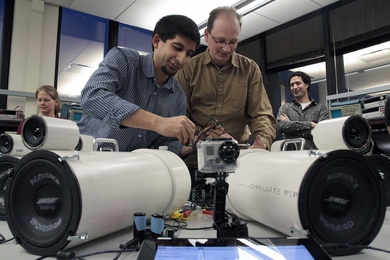 Workshop co-organizer Darius Mobed SM '07 and Zamir connect an array of the student-made speakers to play loud sounds for a demonstration of Bose noise-canceling technology at the end of the workshop.
