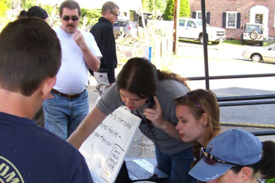 Surrounded by local disaster relief volunteers, Morgan and Caitria O’Neill, center, began developing recovers.org, an innovative recovery platform, last summer in the wake of a tornado that ravaged their hometown — and their own home — in western Massachusetts.