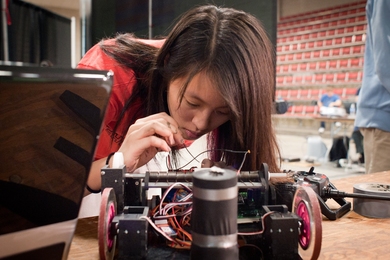 A student in 2.007 makes last-minute adjustments to her robot.