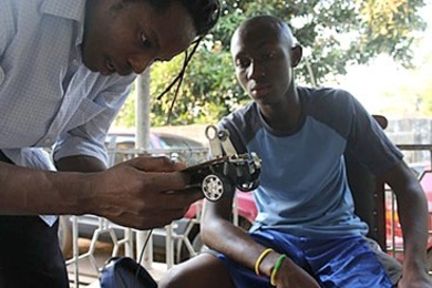 Mohamed Harding (right) reviews the wiring of his autonomous robot with mentor David Sengeh.