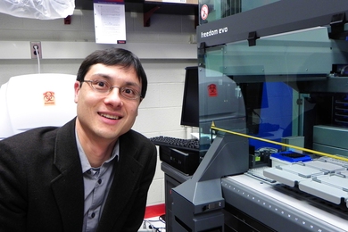 MIT Assistant Professor of Physics Jeff Gore in his lab with Tecan Freedom Evo pipetting robot that will be used to study evolution of cooperative behaviors in single-celled yeast.