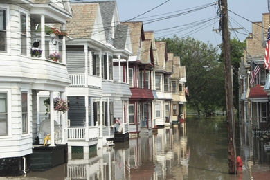 Power lines next to multi family homes and a flooded street