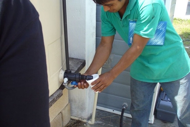 A village resident drinks purified water from the system's clean water tank.