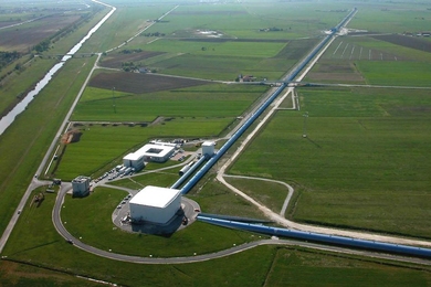 An aerial view of the Virgo site shows the Mode-Cleaner building, the Central building, the 3km-long west arm and the beginning of the north arm. The other buildings include offices, workshops, computer rooms and the control room of the interferometer.