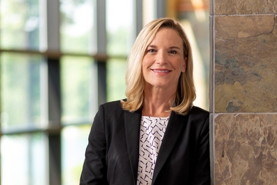 Photo of Denise Johnson leaning against stone wall