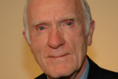 Headshot of an older man who is smiling slightly at the camera