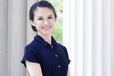 Photo of Meicen Sun standing between two columns of an MIT building
