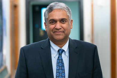 Portrait photo of Anantha Chandrakasan standing in a hallway