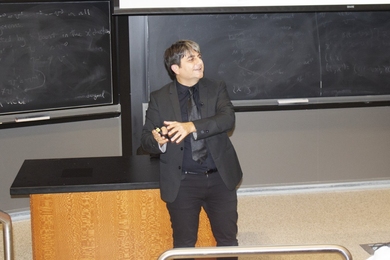Cem Tasan gives a talk in front of a blackboard