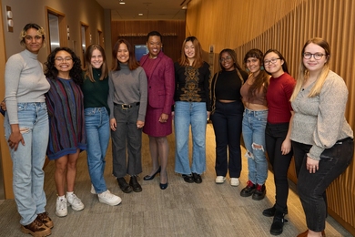 Nine award winners standing indoors in an arc with Melissa Nobles in the center
