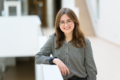 Portrait photo of Kathrin "Kat" Kajderowicz leaning against a railing