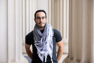 Photo of Ubadah Sabbagh standing amid large columns at MIT