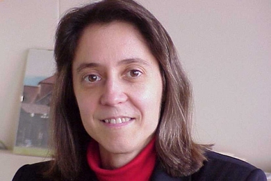 Professor Judy Hoyt is shown smiling gently in her MIT office.
