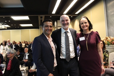 Paulo Lozano, Agustín Rayo, and Griselda Gómez pose for a photo together in a crowded room