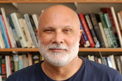 Owen Coté in front of bookshelves