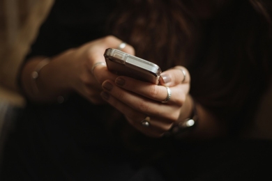 Close-up photo of a pair of hands operating a cell phone