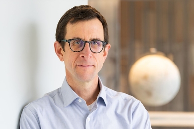 Headshot of David McGee with an out-of-focus globe in the background