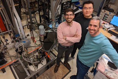 overhead view of three physicists in the lab