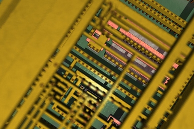 Very close-up photo of a computer chip, with mostly green and yellow components