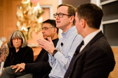 Side view of four people seated on a panel