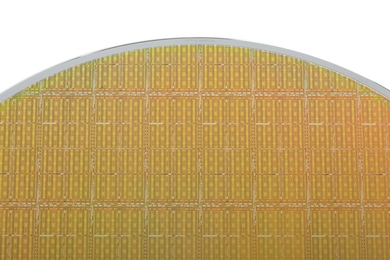 Close-up of a golden silicon disk against a white background. About 100 integrated circuits are visible within the disk.