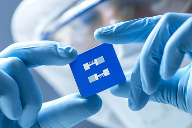 A lab worker holding a sensor chip