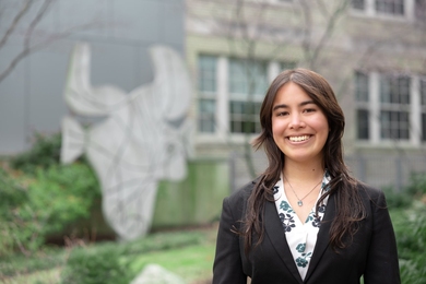 Photo of Haley Nakamura standing in front of a sculpture that looks like a bull's head