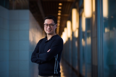 Gene-Wei Li poses in a dimly lit hallway