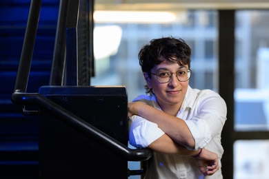 Palak Patel poses in a stairwell, leaning on a railing
