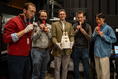 Five men stand in a semicircle. Four are blowing into replica whistles, while one holds an ancient whistle in a protective cradle.