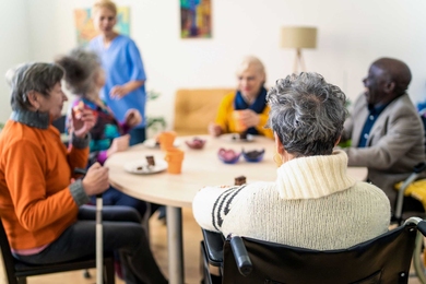 A group of elderly people and a blurry nurse.